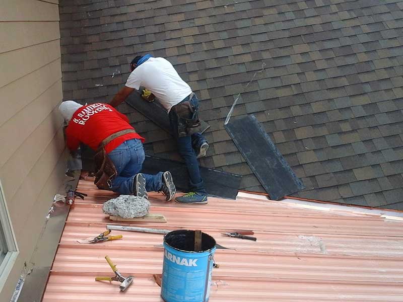 Two B. Ramirez Roofing team members working on a residential roof
